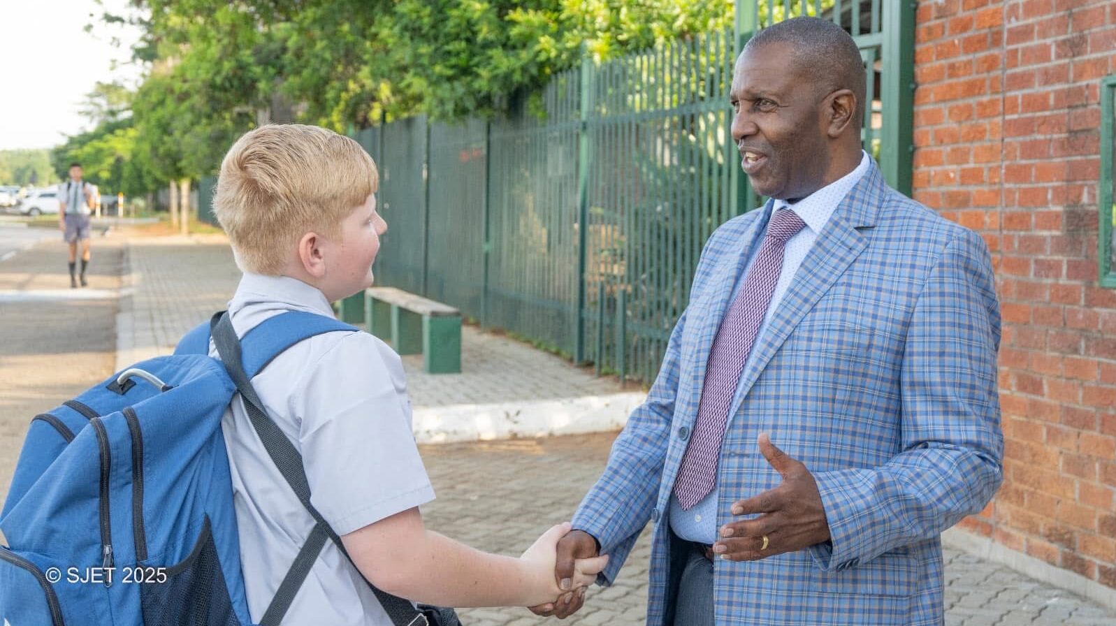 Sam Shaking hands with student